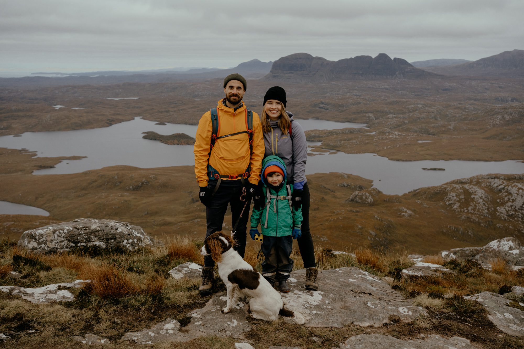 family on top of stac pollaidh with springer spaniel